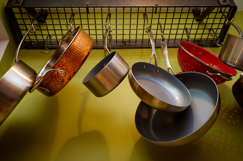 A collection of cooking pans hanging from a rack